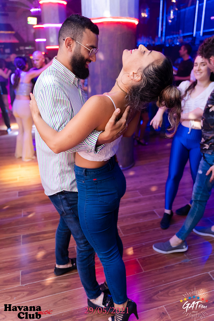 Man dressed in black dancing with woman in white top