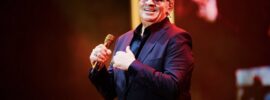 Tito Nieves smiles in front of a packed coliseum
